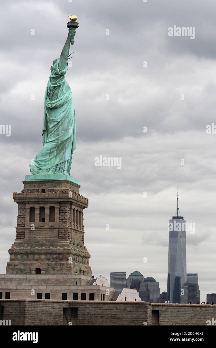 Die Freiheitsstatue auf Liberty Island, New York mit dem Freedom Tower im Hintergrund Stockfoto