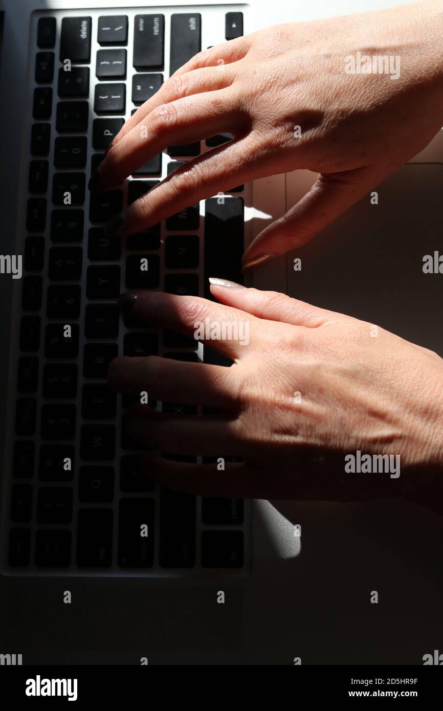 Hände der Frau, die auf dem Laptop tippen Stockfoto