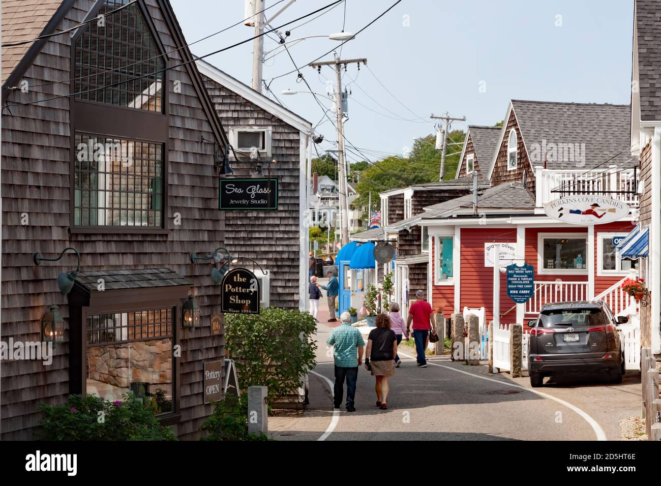 Touristen, die entlang der Harbour Lane durch die Geschäfte in Perkins Cove, Ogunquit, Massachusetts laufen. Stockfoto