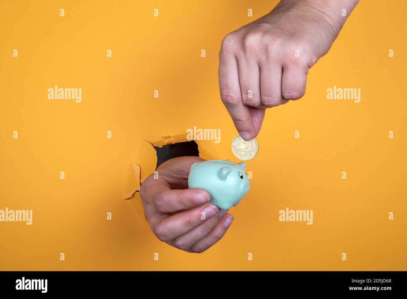 Weibliche Hand legt eine Münze in ein Sparschwein. Ersparnisse, Gewinne, Studien und Home Loan Konzept. Abstrakter Hintergrund Stockfoto