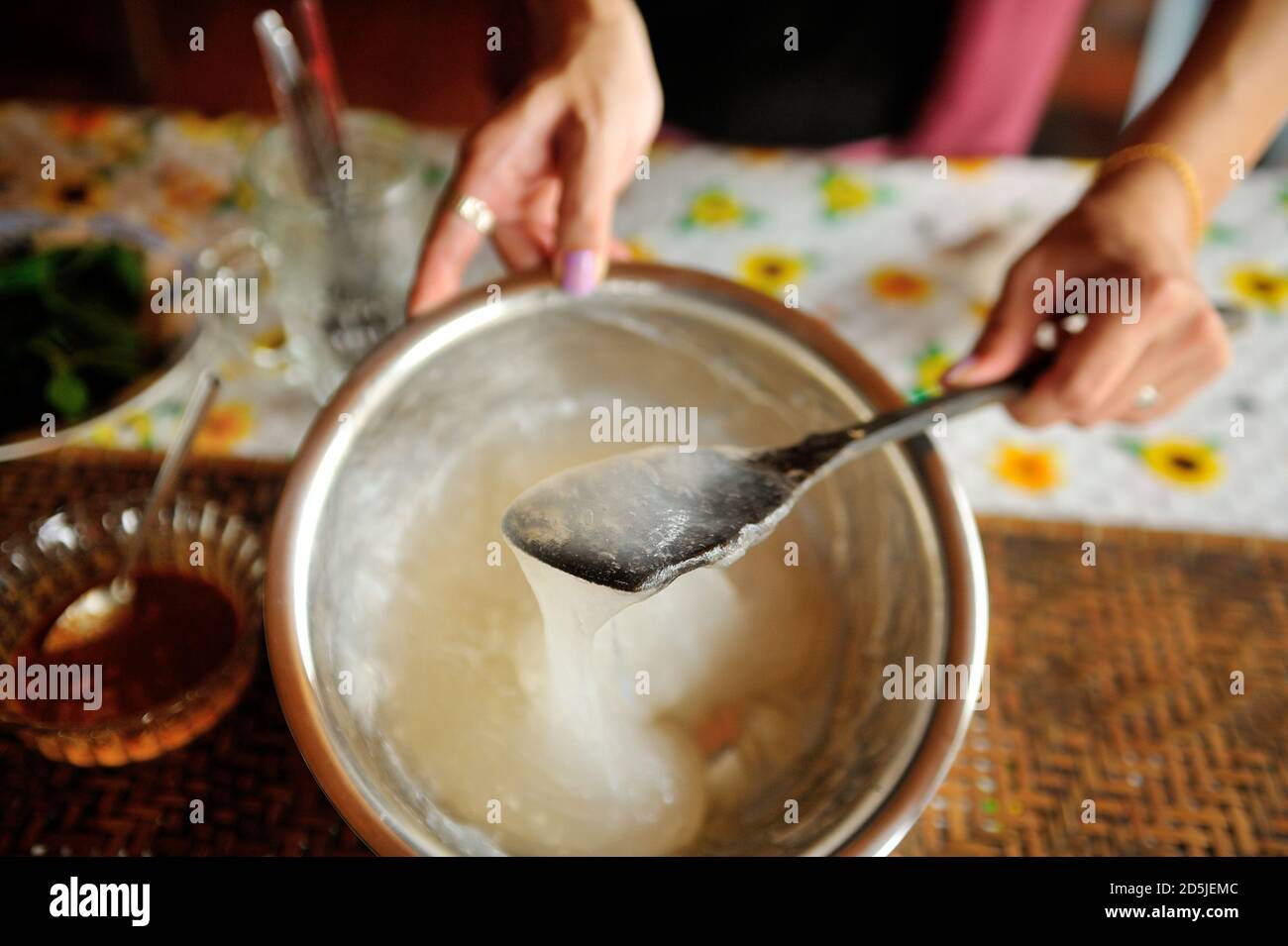 Hand Schneebesen Mischung Zutat von Ambuyat (Brunei Nationalgericht) auf Behälter. Stockfoto