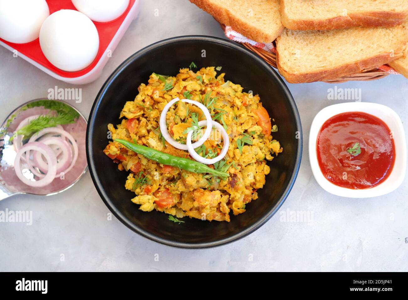 Indisches Frühstücksgericht: Parsi Akuri oder Anda Bhurji oder indische, würzige Rühreier, serviert mit geröstetem braunem Brot und Ketchup. Berühmte indische Street Food Stockfoto