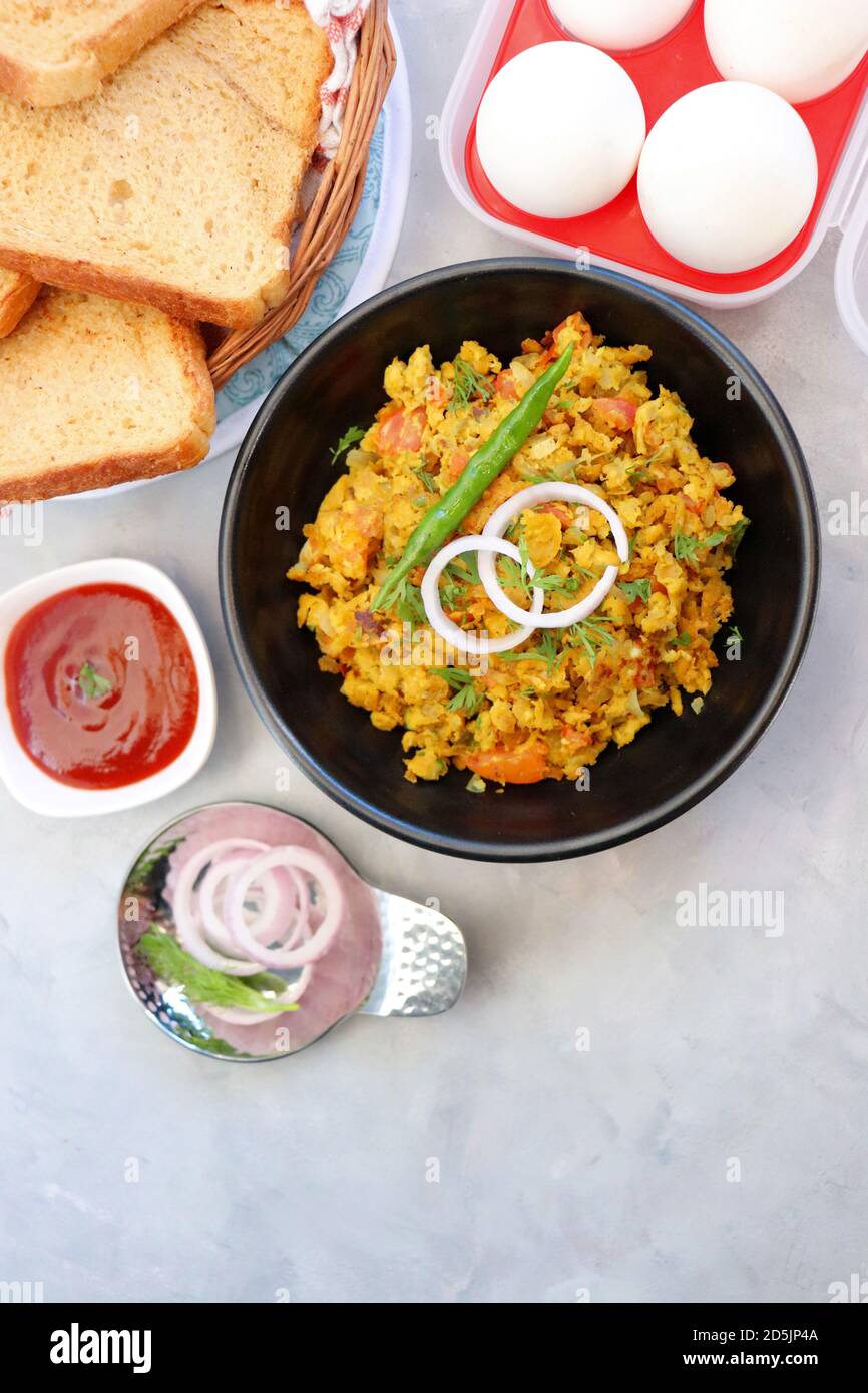 Indisches Frühstücksgericht: Parsi Akuri oder Anda Bhurji oder indische, würzige Rühreier, serviert mit geröstetem braunem Brot und Ketchup. Berühmte indische Street Food Stockfoto