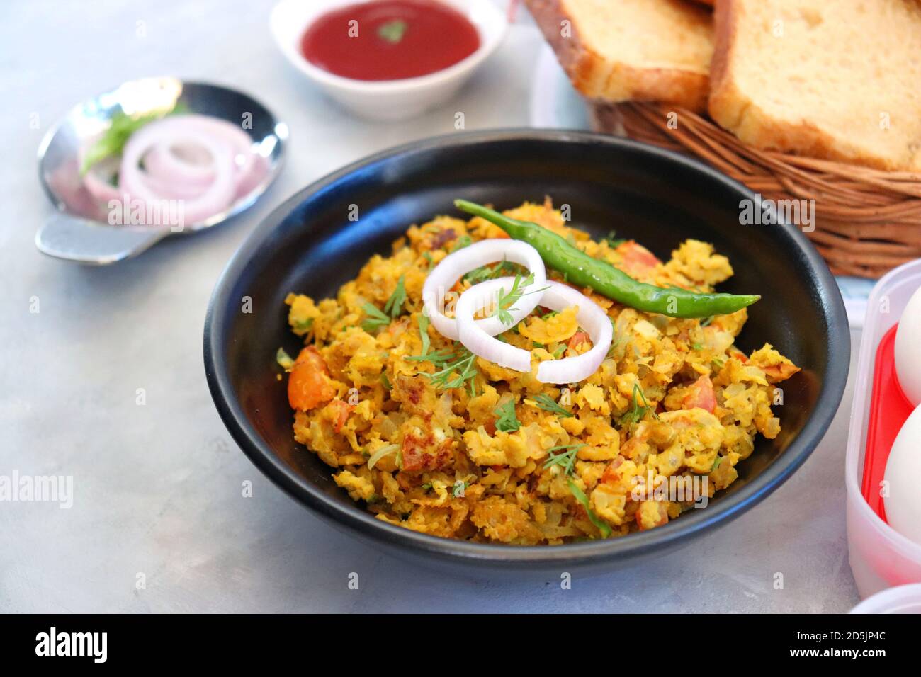 Indisches Frühstücksgericht: Parsi Akuri oder Anda Bhurji oder indische, würzige Rühreier, serviert mit geröstetem braunem Brot und Ketchup. Berühmte indische Street Food Stockfoto
