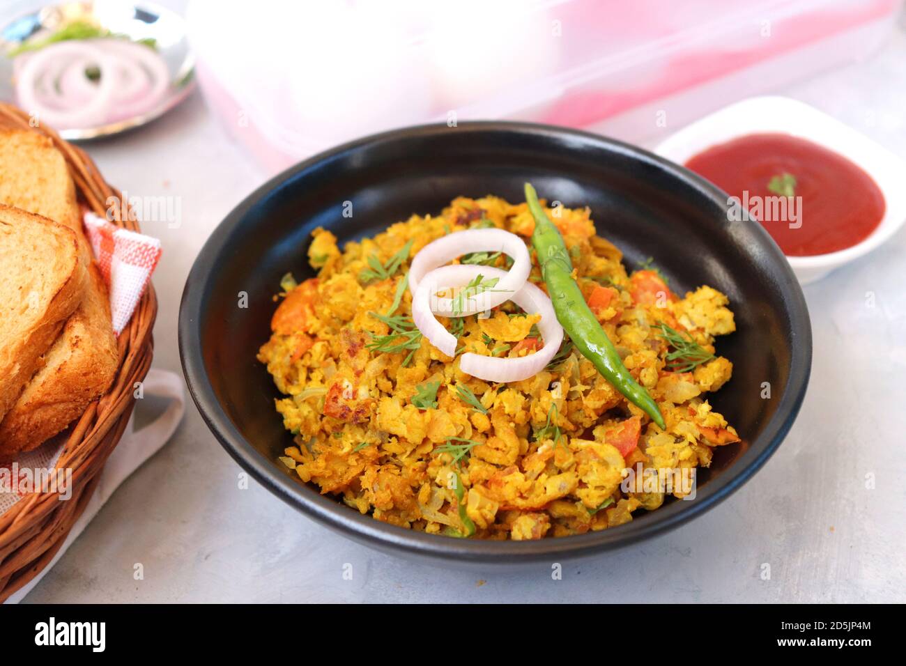 Indisches Frühstücksgericht: Parsi Akuri oder Anda Bhurji oder indische, würzige Rühreier, serviert mit geröstetem braunem Brot und Ketchup. Berühmte indische Street Food Stockfoto