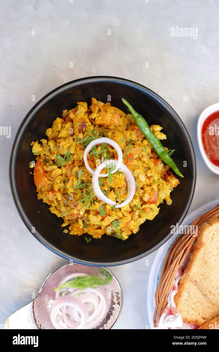 Indisches Frühstücksgericht: Parsi Akuri oder Anda Bhurji oder indische, würzige Rühreier, serviert mit geröstetem braunem Brot und Ketchup. Berühmte indische Street Food Stockfoto