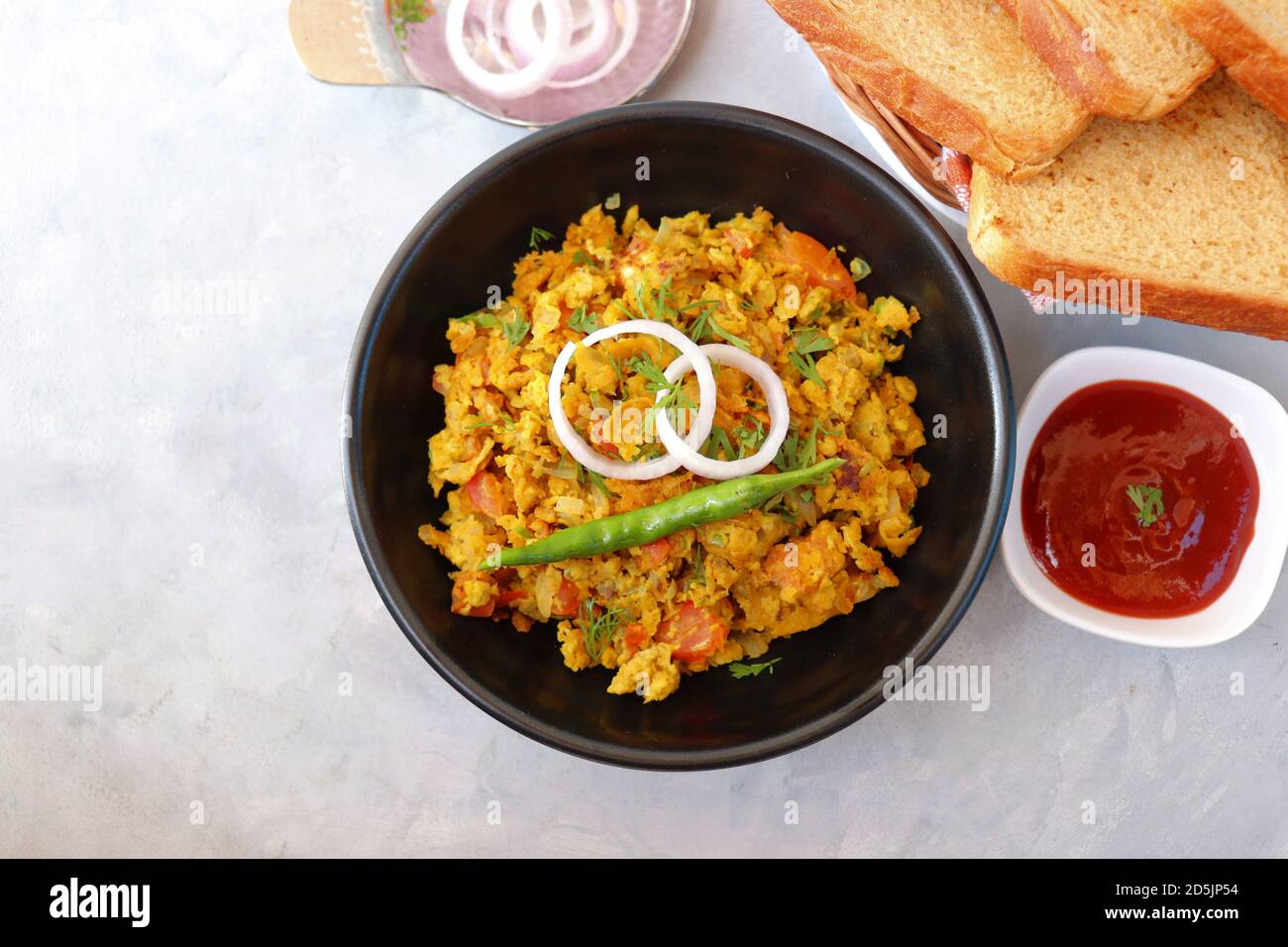 Indisches Frühstücksgericht: Parsi Akuri oder Anda Bhurji oder indische, würzige Rühreier, serviert mit geröstetem braunem Brot und Ketchup. Berühmte indische Street Food Stockfoto