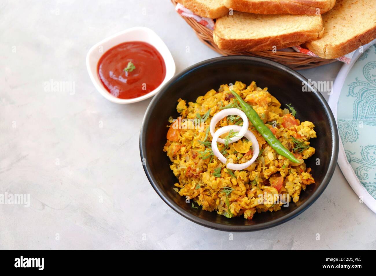 Indisches Frühstücksgericht: Parsi Akuri oder Anda Bhurji oder indische, würzige Rühreier, serviert mit geröstetem braunem Brot und Ketchup. Berühmte indische Street Food Stockfoto