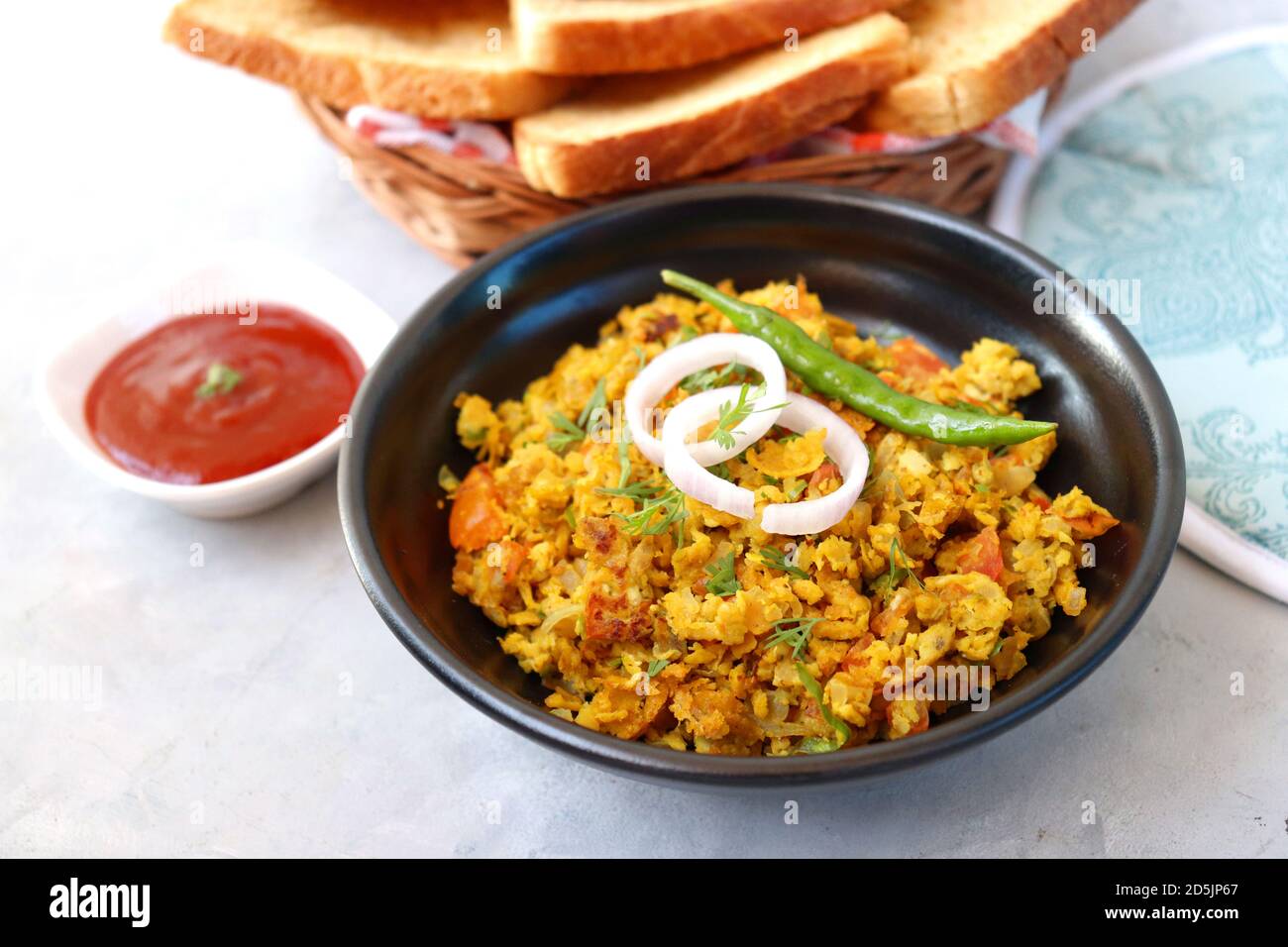Indisches Frühstücksgericht: Parsi Akuri oder Anda Bhurji oder indische, würzige Rühreier, serviert mit geröstetem braunem Brot und Ketchup. Berühmte indische Street Food Stockfoto