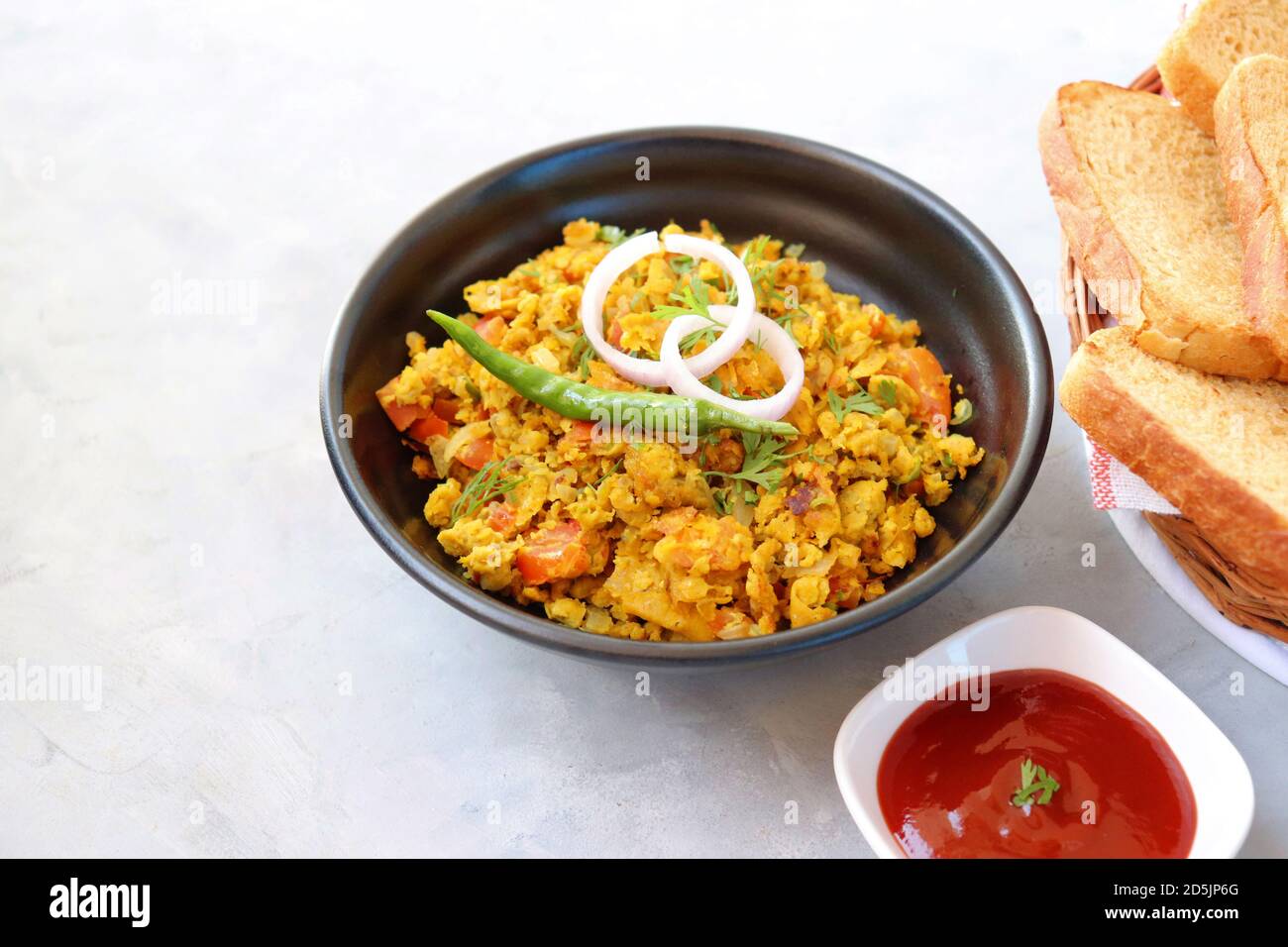 Indisches Frühstücksgericht: Parsi Akuri oder Anda Bhurji oder indische, würzige Rühreier, serviert mit geröstetem braunem Brot und Ketchup. Berühmte indische Street Food Stockfoto