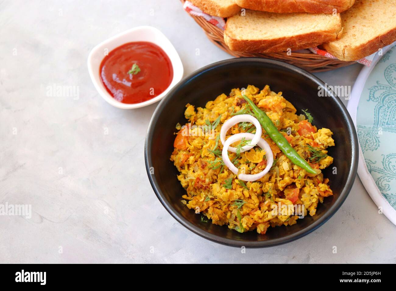 Indisches Frühstücksgericht: Parsi Akuri oder Anda Bhurji oder indische, würzige Rühreier, serviert mit geröstetem braunem Brot und Ketchup. Berühmte indische Street Food Stockfoto