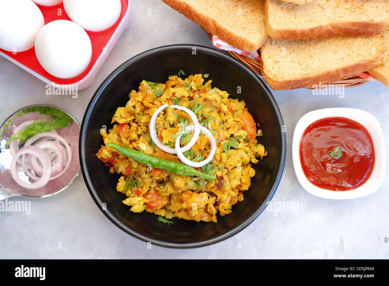 Indisches Frühstücksgericht: Parsi Akuri oder Anda Bhurji oder indische, würzige Rühreier, serviert mit geröstetem braunem Brot und Ketchup. Berühmte indische Street Food Stockfoto