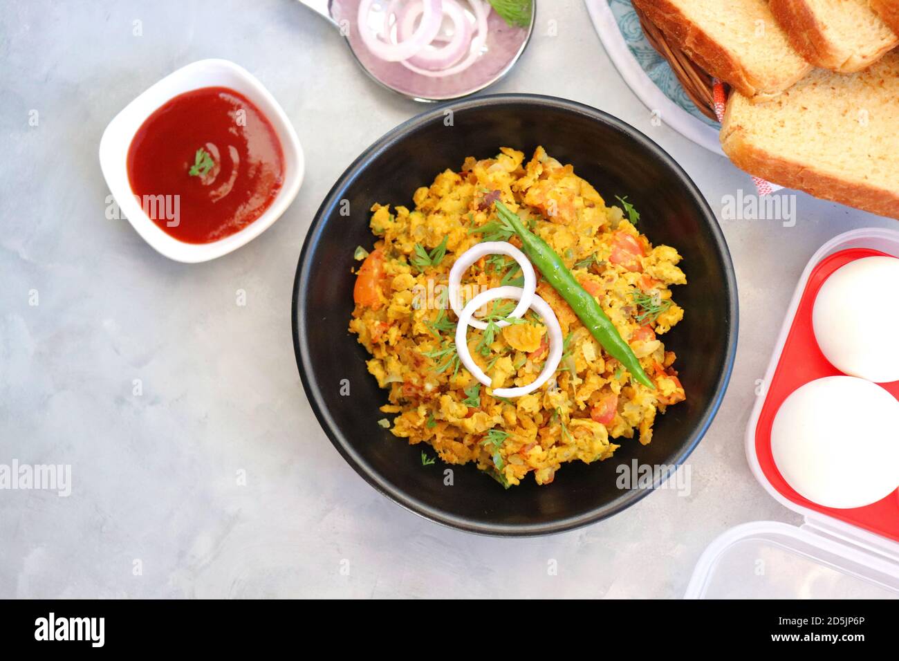 Indisches Frühstücksgericht: Parsi Akuri oder Anda Bhurji oder indische, würzige Rühreier, serviert mit geröstetem braunem Brot und Ketchup. Berühmte indische Street Food Stockfoto