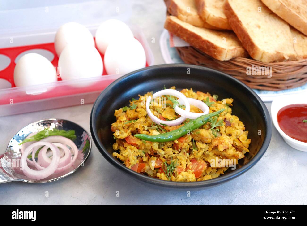 Indisches Frühstücksgericht: Parsi Akuri oder Anda Bhurji oder indische, würzige Rühreier, serviert mit geröstetem braunem Brot und Ketchup. Berühmte indische Street Food Stockfoto