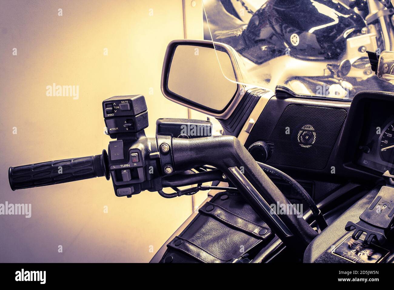 Nahaufnahme der linken Seite des Motorrad-Lenkrads. Moto-Griff und Kupplungshebel, mit Windschutzscheibe, Spiegel, Lautsprecher, Tachometer, Audio-Steuerungstaste Stockfoto