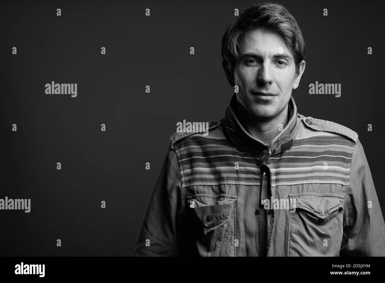 Schöner Mann mit Mantel auf grauem Hintergrund Stockfoto