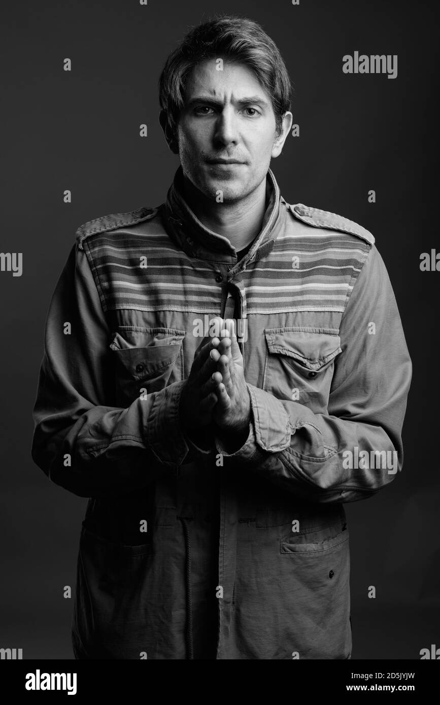 Schöner Mann mit Mantel auf grauem Hintergrund Stockfoto