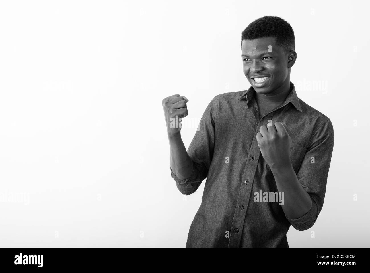 Studio shot der Jungen glücklich schwarzen afrikanischen Mann lächelnd, während sie gegen den weißen Hintergrund begeistert Stockfoto