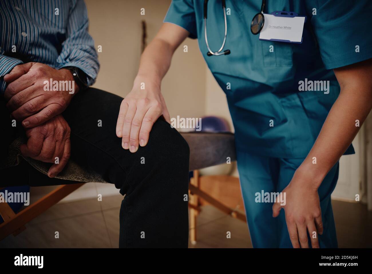 Nahaufnahme der Hände der weiblichen Physiotherapeutin, die das Knie des Senior untersucht Männlicher Patient in der Klinik Stockfoto