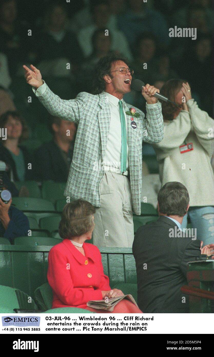 03-JUL-96 ... Wimbledon 96 ... Cliff Richard unterhält die Massen während des Regens auf dem Center Court Stockfoto