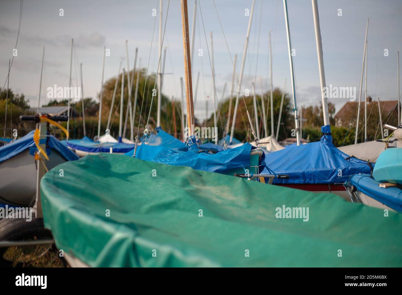 Segelboote mit Masten in der Luft in einem Bootswerft in England bedeckt. Wassersport Segeln Südküste. Stockfoto