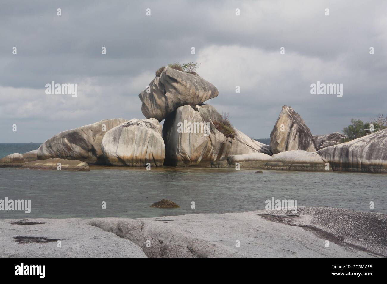 Felsbrocken, die durch natürliche Prozesse am Strand aufgestapelt werden Stockfoto