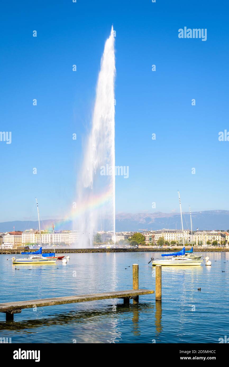 Die Genfer Bucht an einem sonnigen Sommermorgen mit einem Regenbogen, der auf dem Jet d'Eau, dem 140 Meter hohen Wasserstrahlbrunnen am Genfer See, auftaucht. Stockfoto