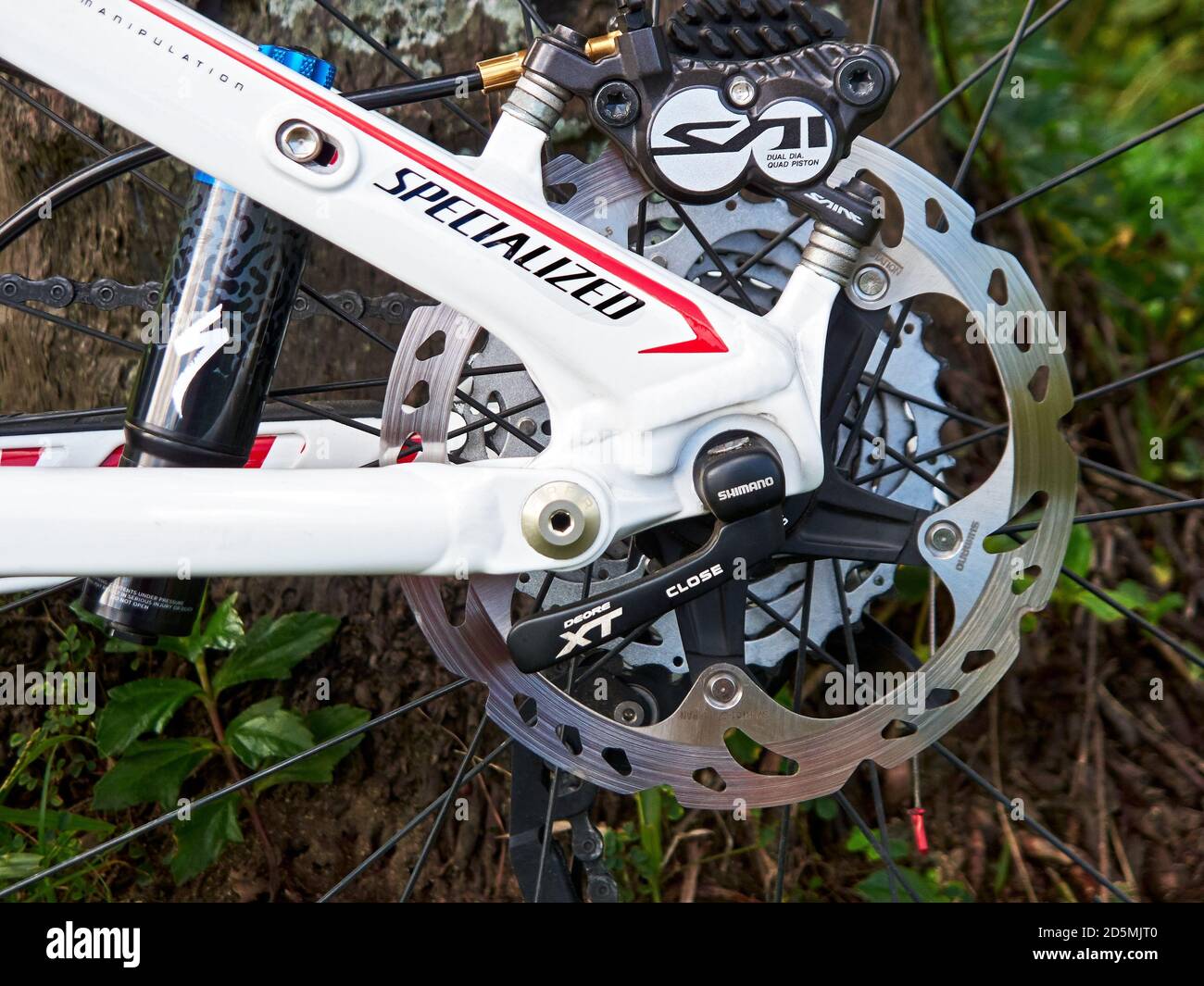 Nahaufnahme eines speziellen Epic Mountainbike-Rahmens mit einem Shimano Saint Hinterrad-Scheibenbremsen-Rotor aus glänzendem Metall, mit natürlichem Hintergrund Stockfoto