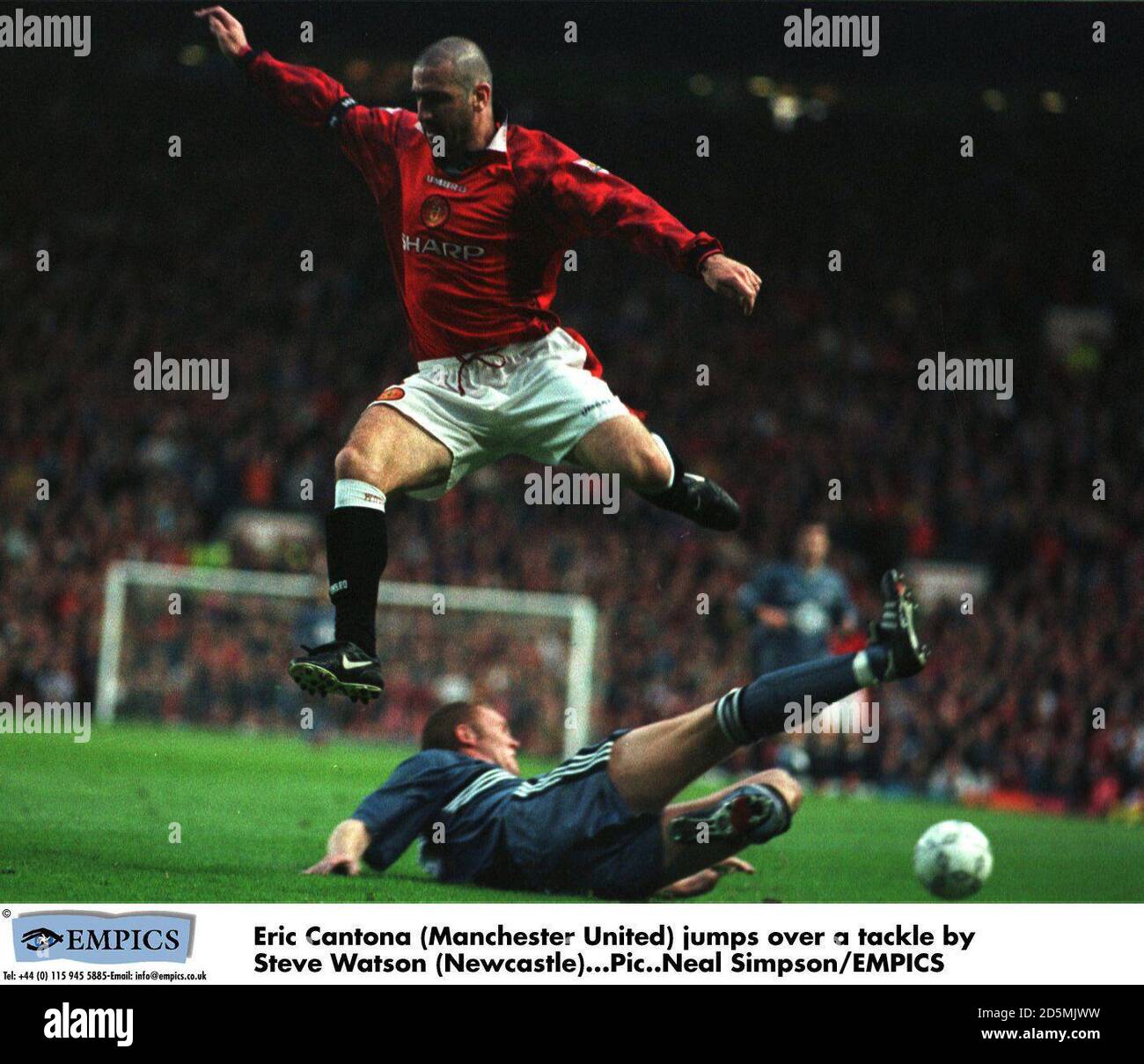 Eric Cantona (Manchester United) Springt über ein Tackle von Steve Watson (Newcastle) Stockfoto