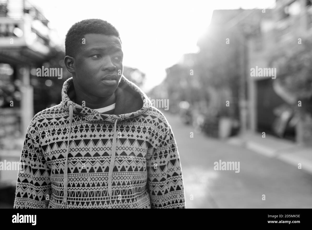 Jungen schwarzen afrikanischen Mann denken, während auf die Seite und tragen Hoodie im Freien Stockfoto