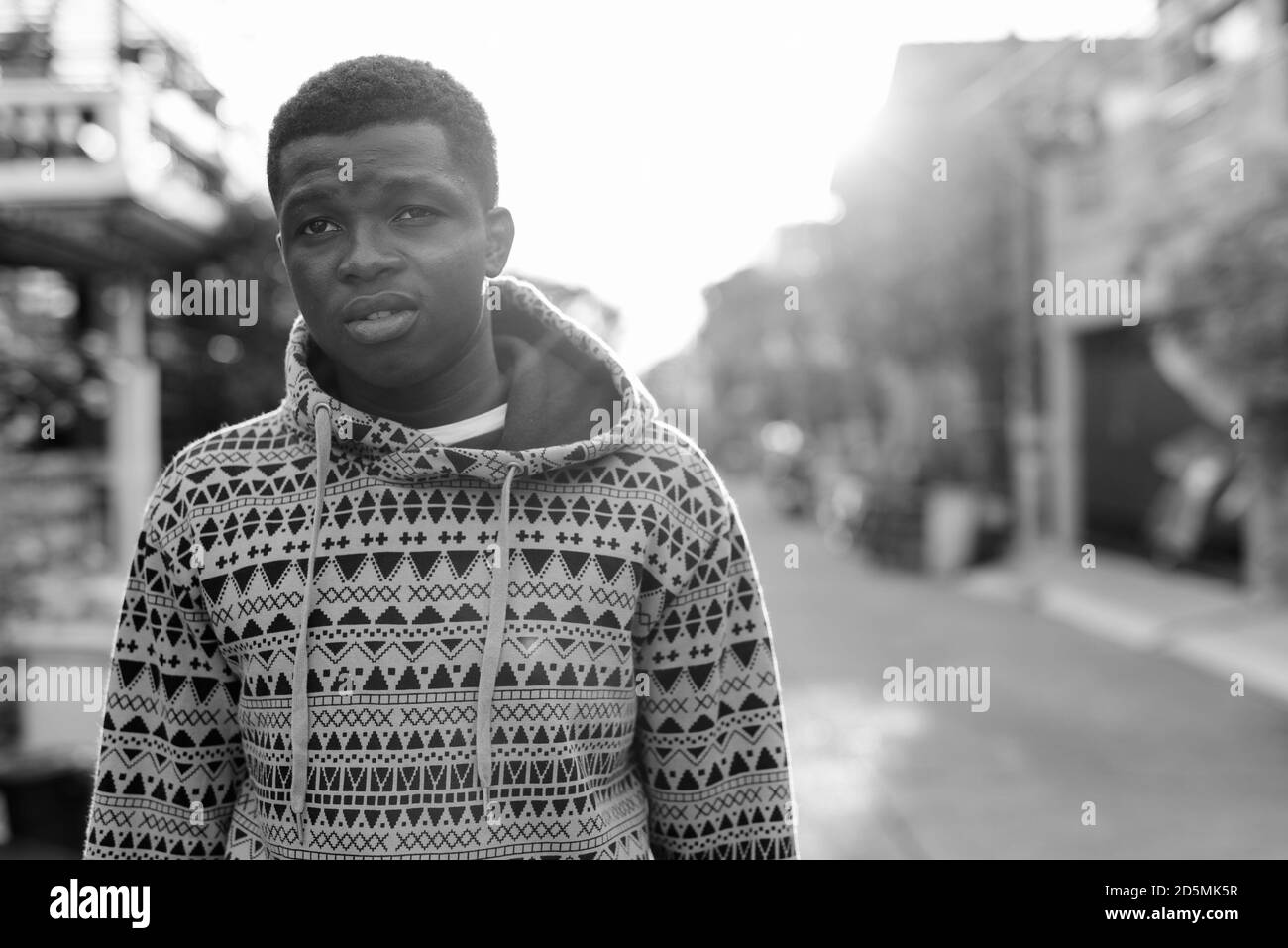 Jungen schwarzen afrikanischen Mann denken, während Sie Abstand und tragen Hoodie im Freien Stockfoto