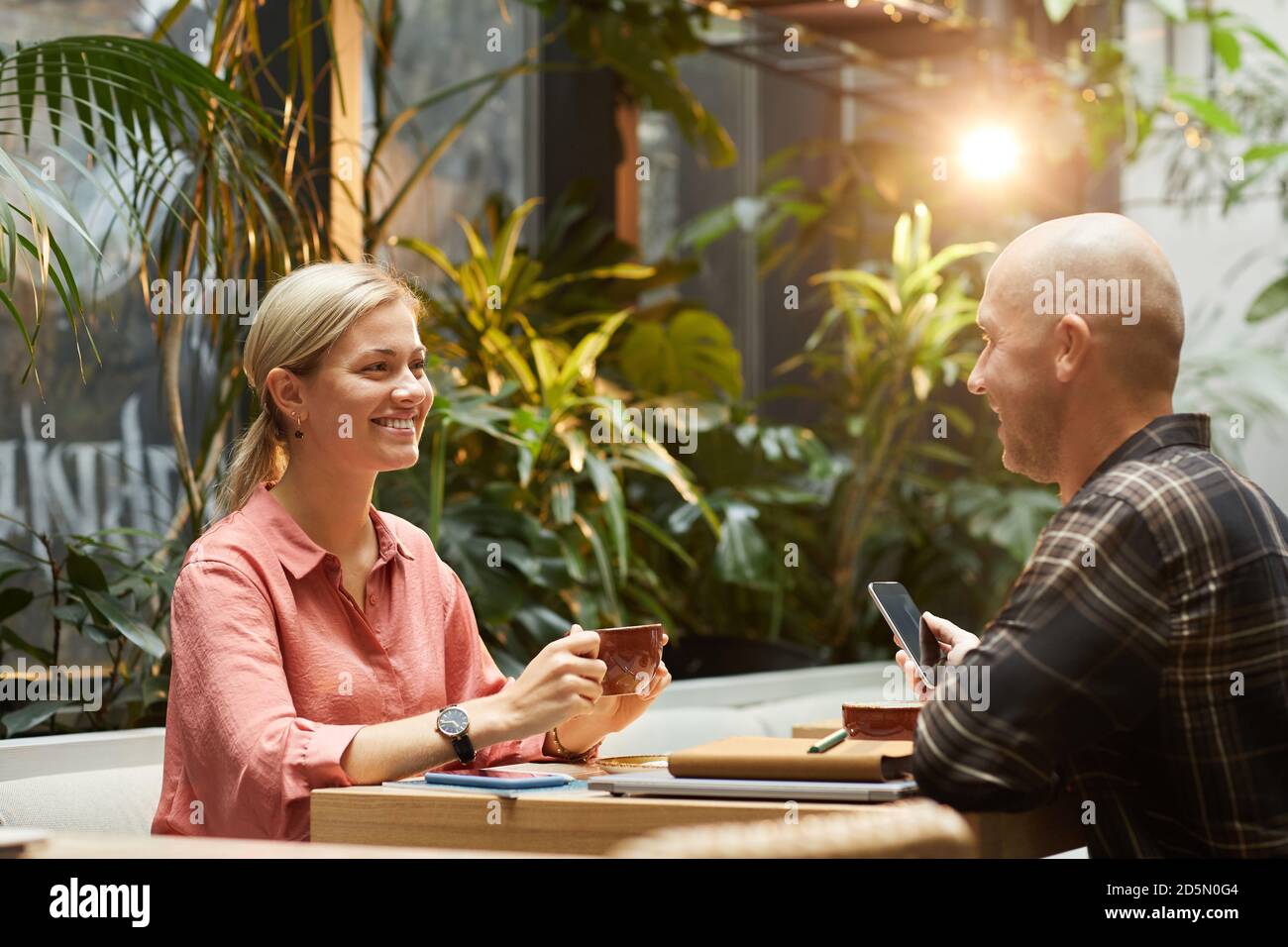 Glückliches junges Paar, das miteinander spricht und Kaffee trinkt Während des Datums im Café Stockfoto