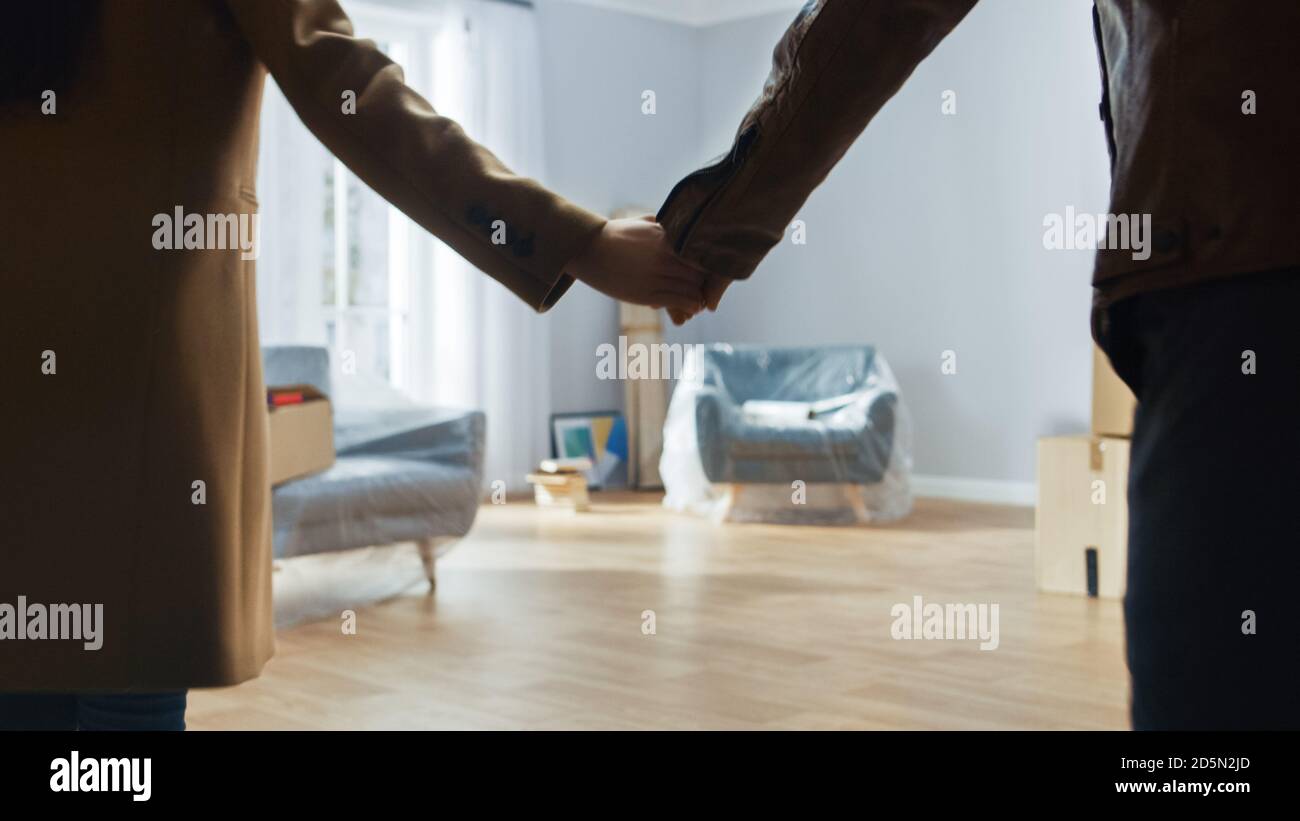 Aufgeregt Junges Paar Holding Hände Betritt Neu Gekauft / Vermietet Wohnung. Helles modernes Zuhause für glückliche junge Menschen. Stockfoto
