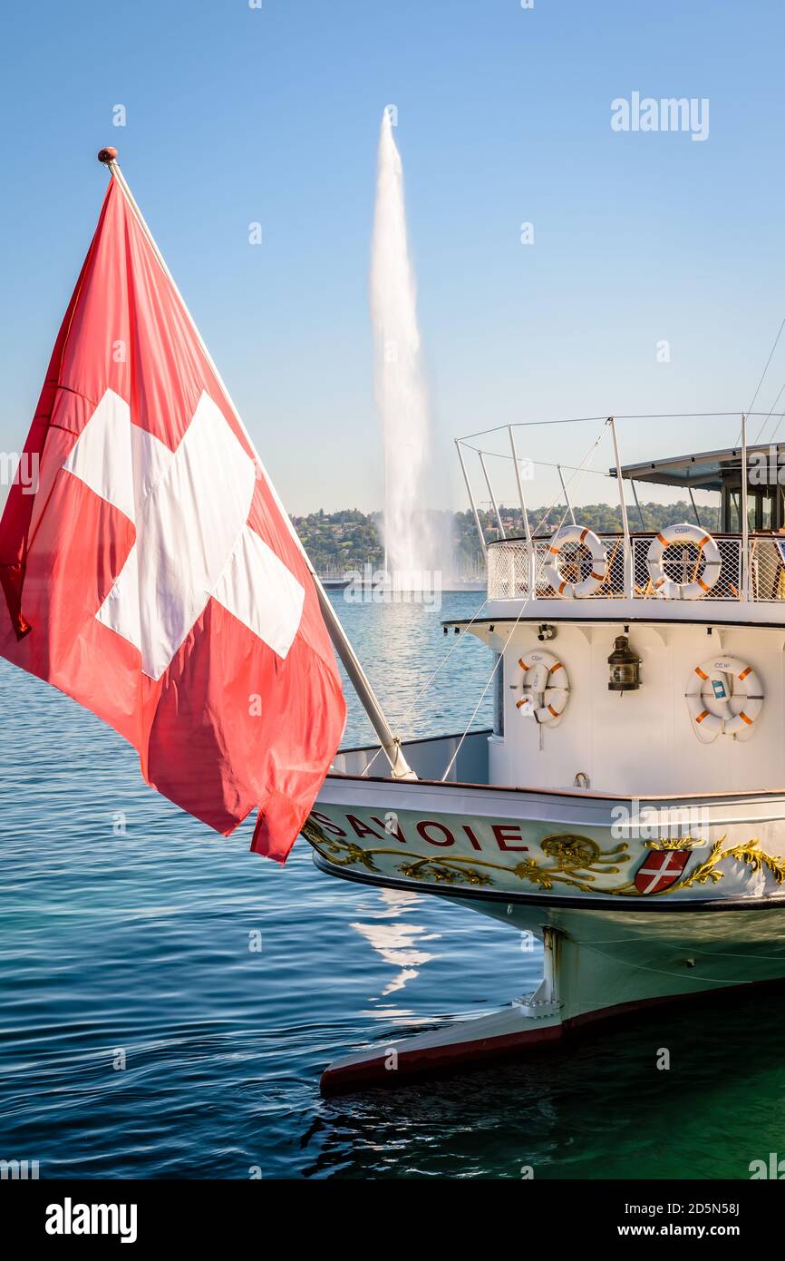 Am Heck des Raddampfers 'Savoie', der in der Genfer Bucht festgemacht ist, mit dem Wasserstrahlbrunnen in der Ferne, fliegt eine große Schweizer Flagge. Stockfoto