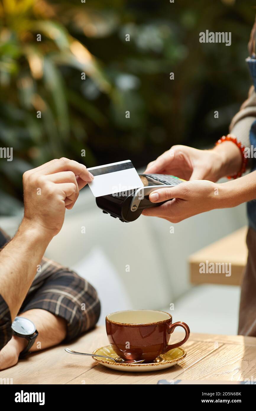 Nahaufnahme des Mannes, der für eine Kaffeetasse mit Kreditkarte bezahlt An den Kellner im Restaurant Stockfoto