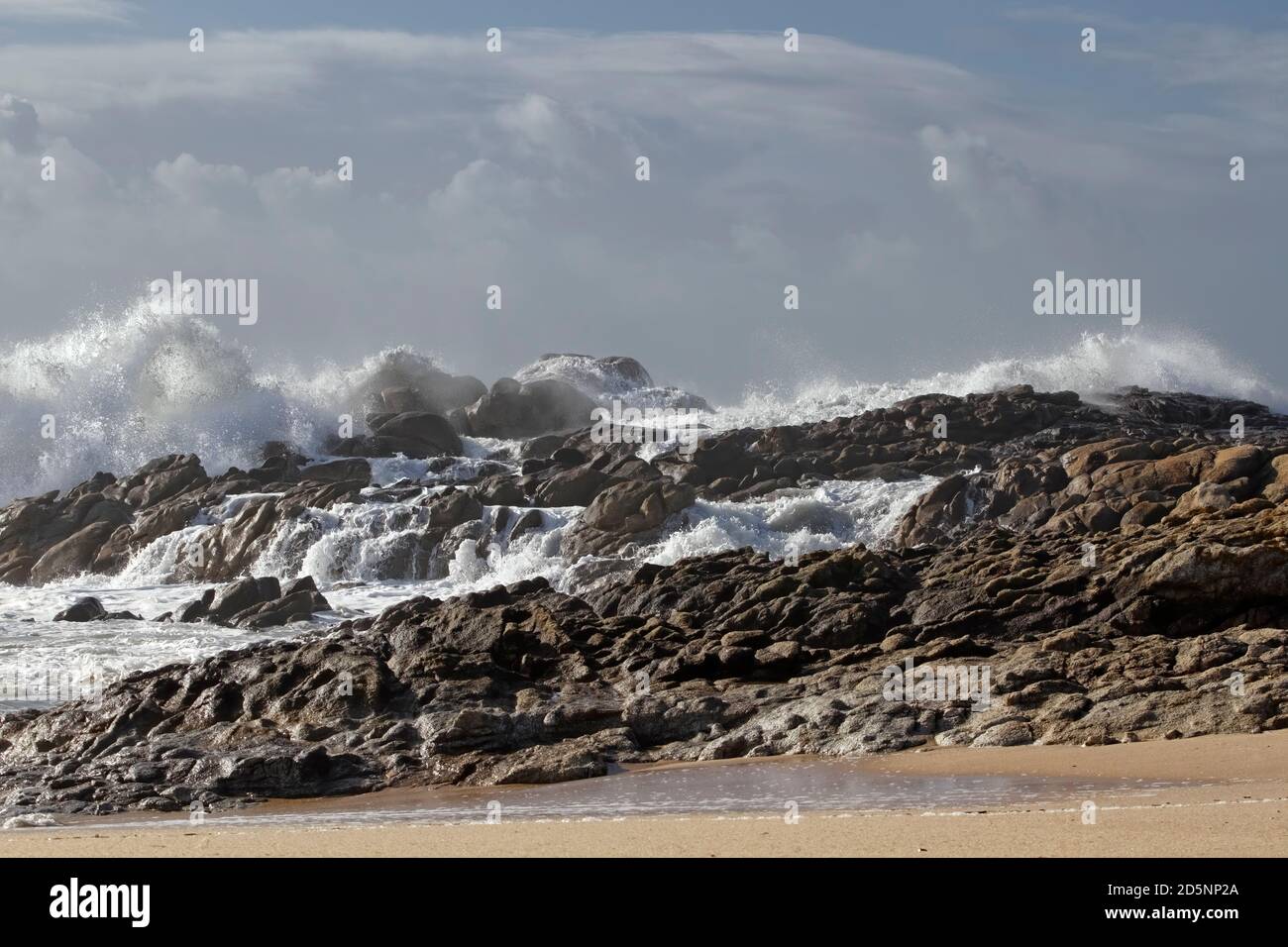 Felsiger Strand aus dem Norden Portugals während der Herbstsaison zu sehen Wellenspritzer und kleine Kaskade Stockfoto