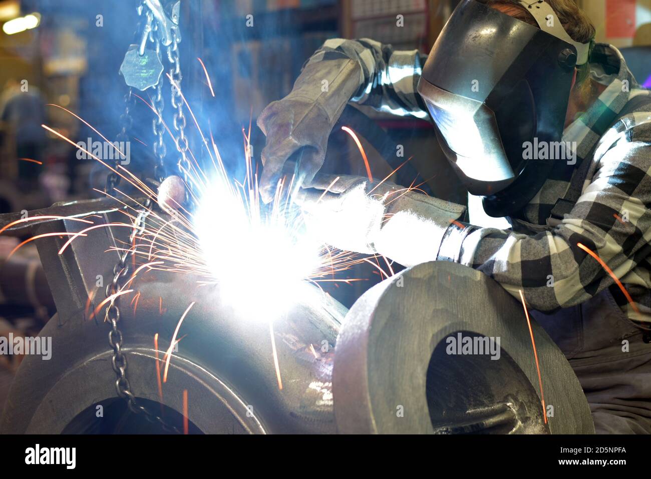 Schweißer in Schutzkleidung am Arbeitsplatz in einer Industrie Unternehmen im Stahlbau Stockfoto