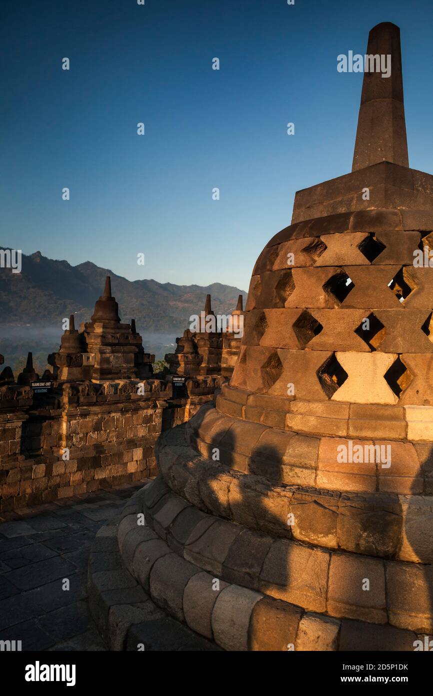 Vertikale Ansicht einer der Stupas der oberen Terrassen des buddhistischen Tempels Borobudur bei Sonnenaufgang, Borobudur, Java, Indonesien Stockfoto