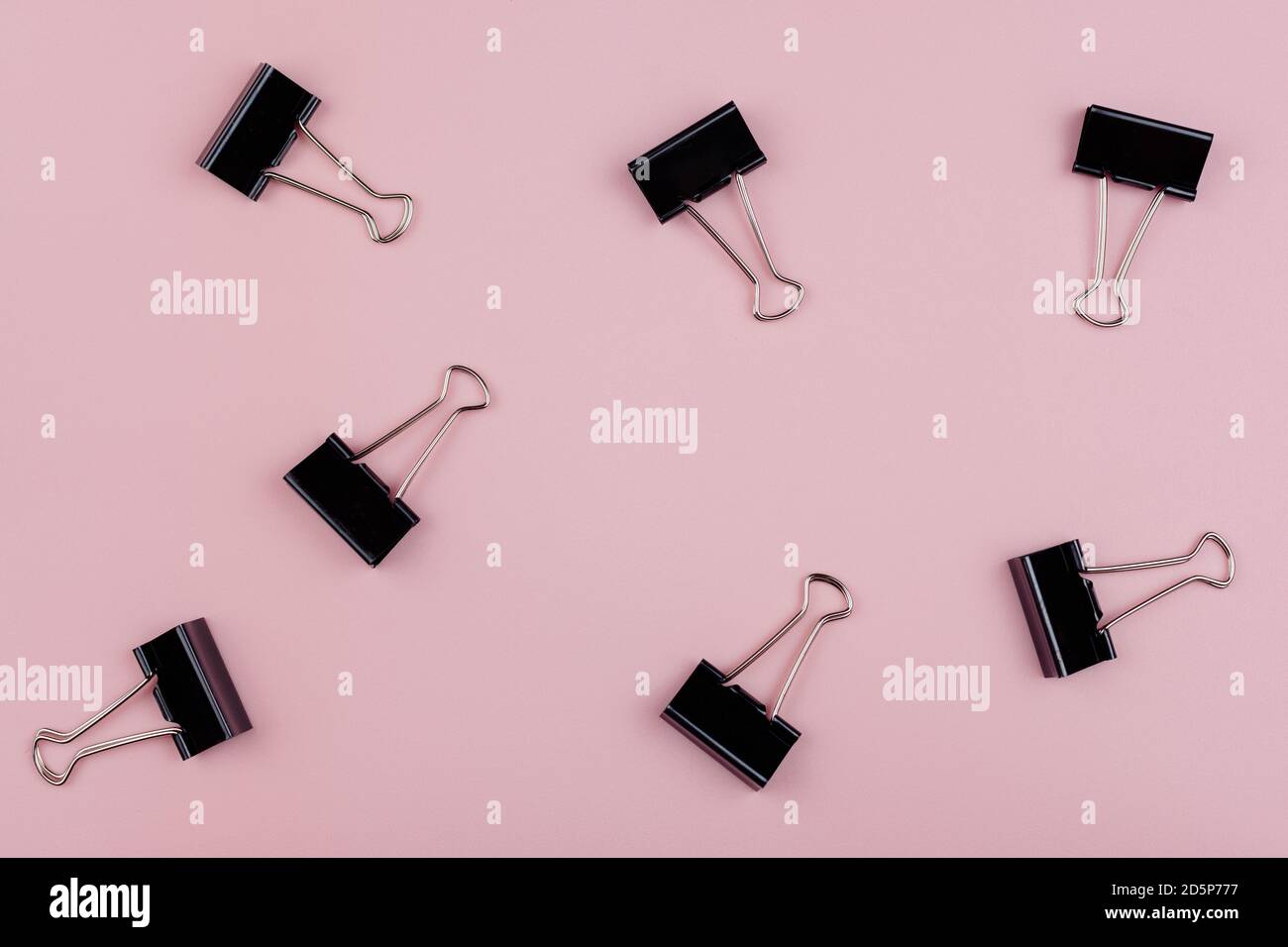 Sieben Büroklammern isoliert auf rosa Hintergrund Stockfoto