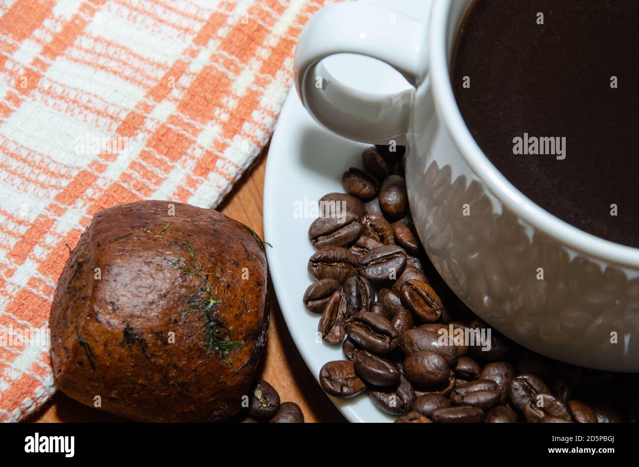 Weiße Tasse mit Kaffeebohnen auf dem Tisch Stockfoto