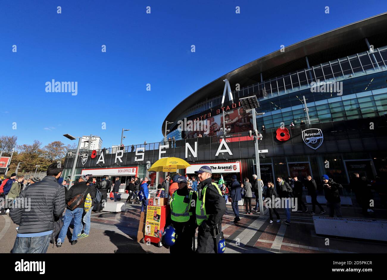 Die Polizei hat ein Auge auf die Verfahren, während Fans herumlaufen Vor dem Spiel Stockfoto