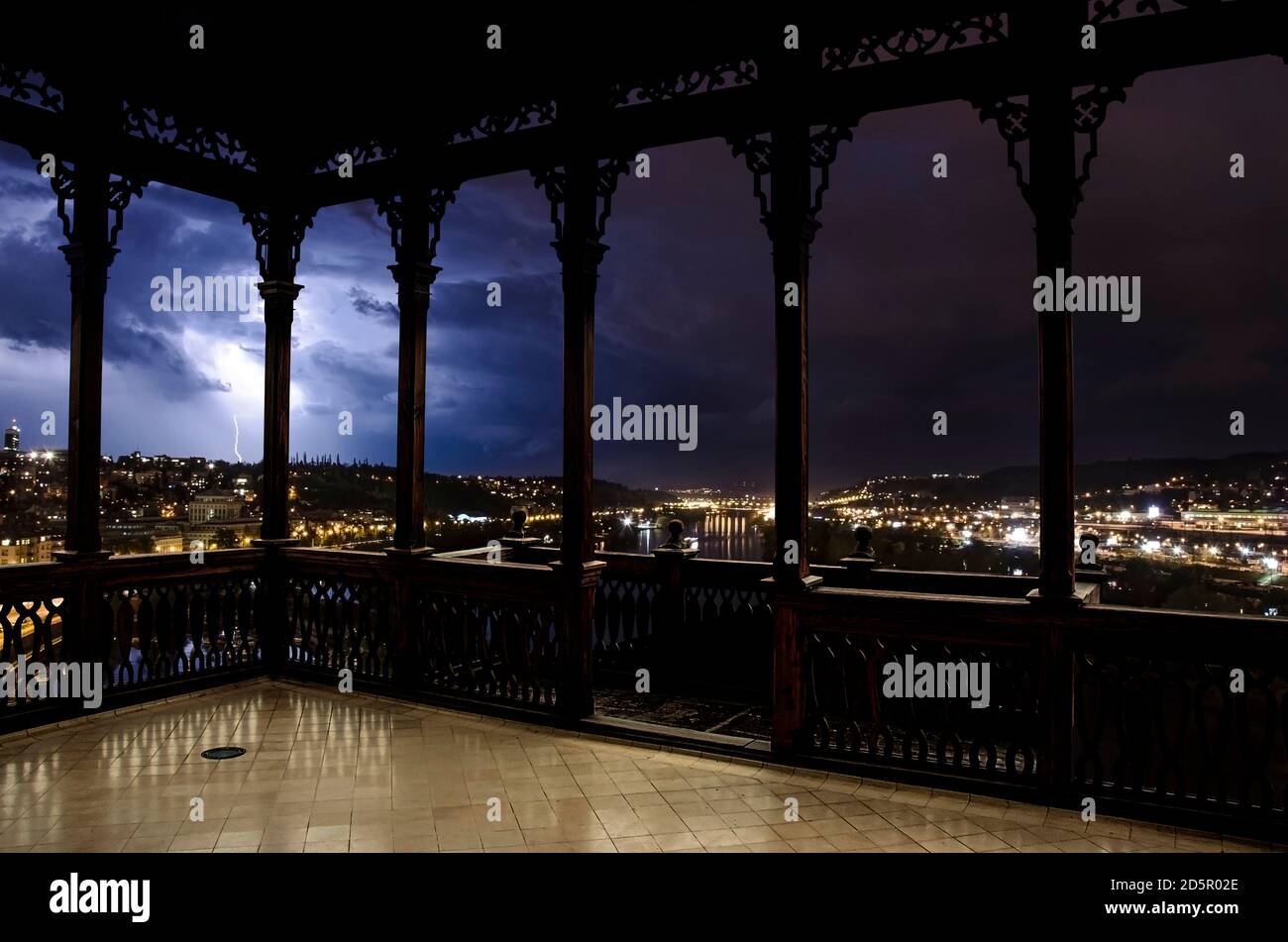 Blick auf beleuchtete Stadt während Gewitter mit Blitz aus Holz durchbrochene Galerie oder Pavillon in Prag, Tschechische Republik. Stockfoto