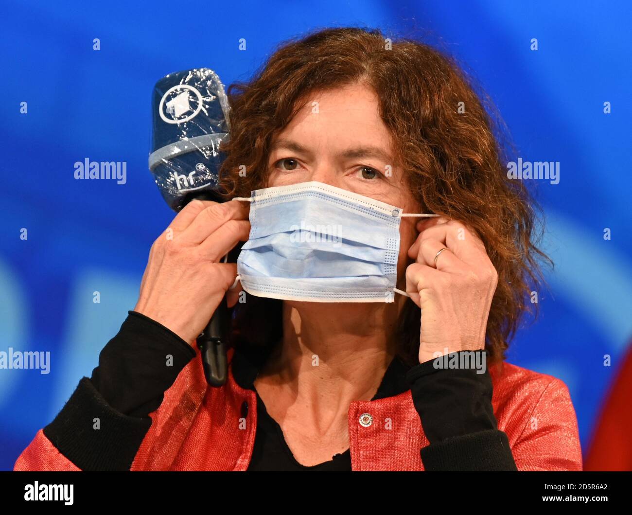 14. Oktober 2020, Hessen, Frankfurt/Main: Die Autorin Anne Weber, Gewinnerin des Deutschen Buchpreises 2020, zieht nach einer Diskussion auf der ARD-Buchmesse-Bühne in der Festhalle einen Mund-Nase-Protektor an. Die korona-bezogene Sonderausgabe 2020 der Buchmesse findet vom 14. Bis 18. Oktober statt. Foto: Arne Dedert/dpa Stockfoto