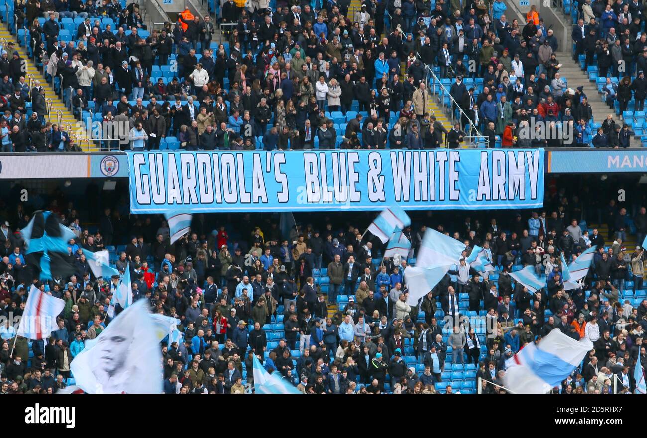 Manchester City Fans mit einem Banner mit Guardiolas blauem und Weiße Armee in den Tribünen Stockfoto