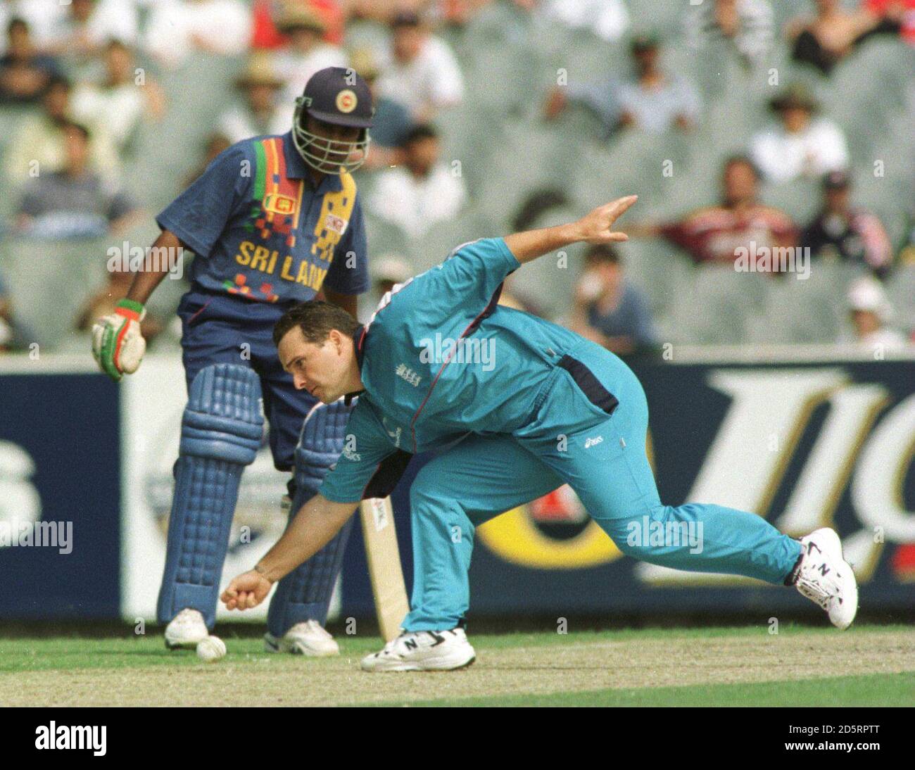 Englands Mark Ealham Felder aus seinem eigenen Bowling vor Sri Lankas Jayawardena Stockfoto