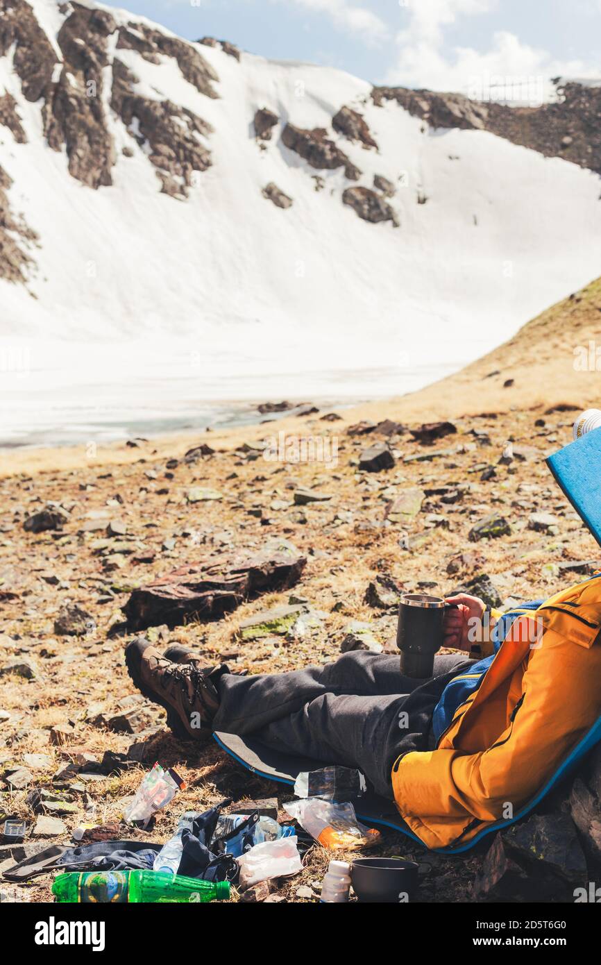 Mann Reisender trinkt Tee, genießen Sie eine wunderbare Aussicht auf den alpinen See in den Bergen sitzen in der Nähe von Campingausrüstung. Outdoor Reisen Abenteuer Lifestyle Co Stockfoto