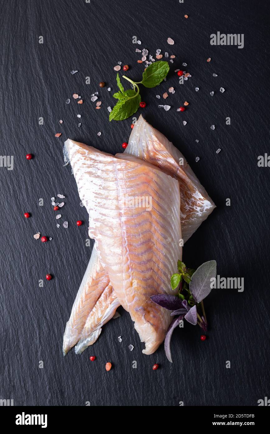 Healthy Food Konzept Draufsicht Rohfilets Alaska Pollock, Black Cod auf schwarzem Schiefersteinbrett mit Kopierraum Stockfoto