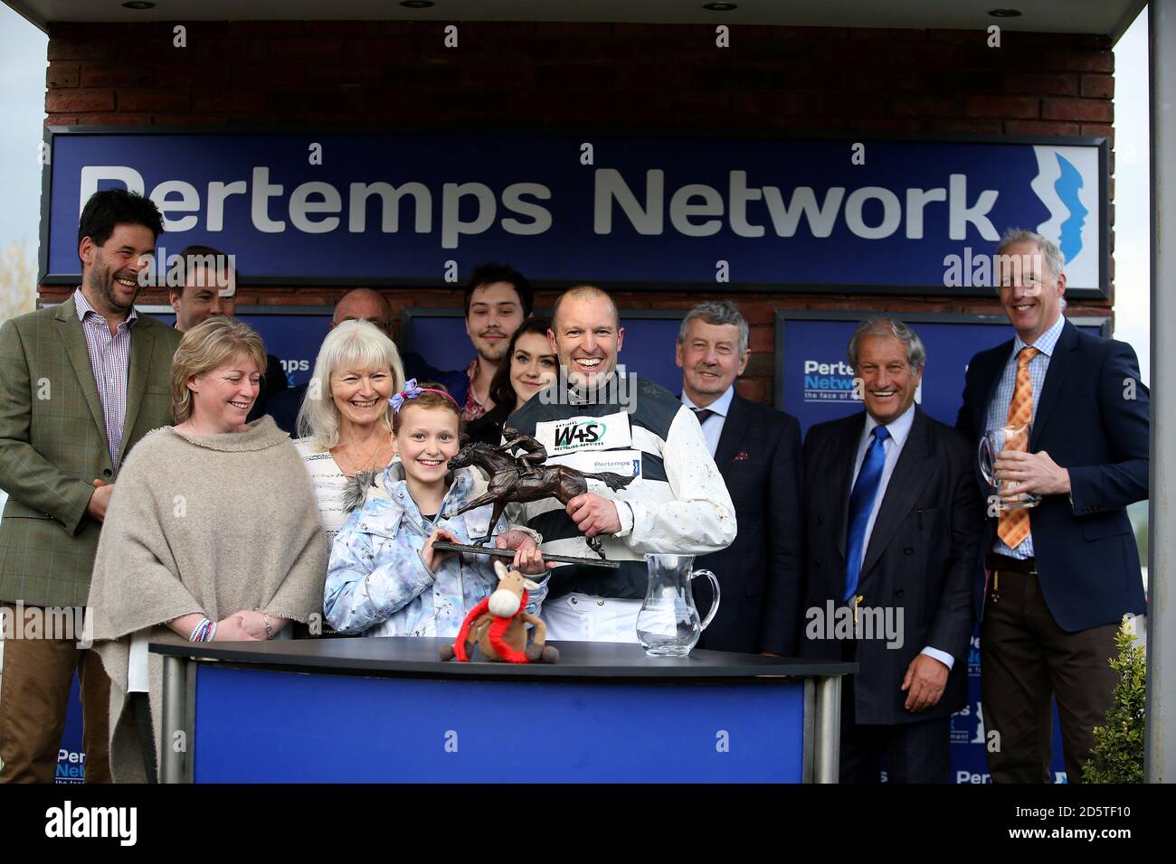 Jockey Ben Moore feiert mit der Trophäe nach dem Gewinn der Pertemps Champions Willberry Charity Race während des Apriltreffens bei Cheltenham Rennbahn Stockfoto