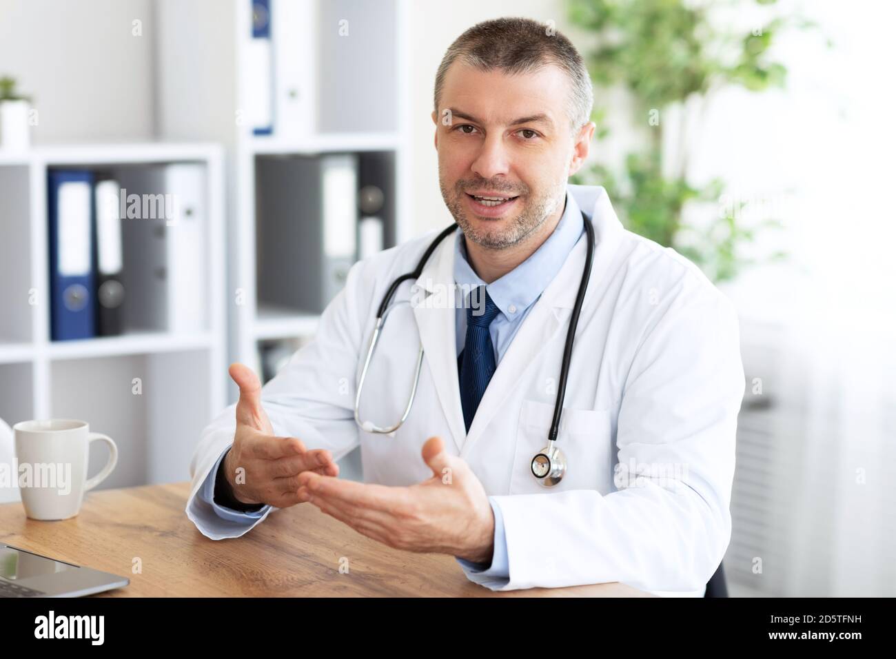 Porträt eines leitenden Arztes, der seinen Klienten, den pov des Patienten, konsultiert Stockfoto