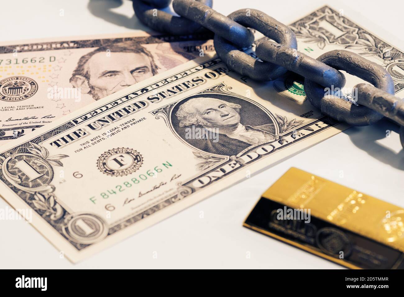 Ein und fünf-Dollar-Scheine, Goldbarren und Stahlkette. Geld, Finanzen, Schulden, Goldstandard und Abschreibungskonzepte Stockfoto